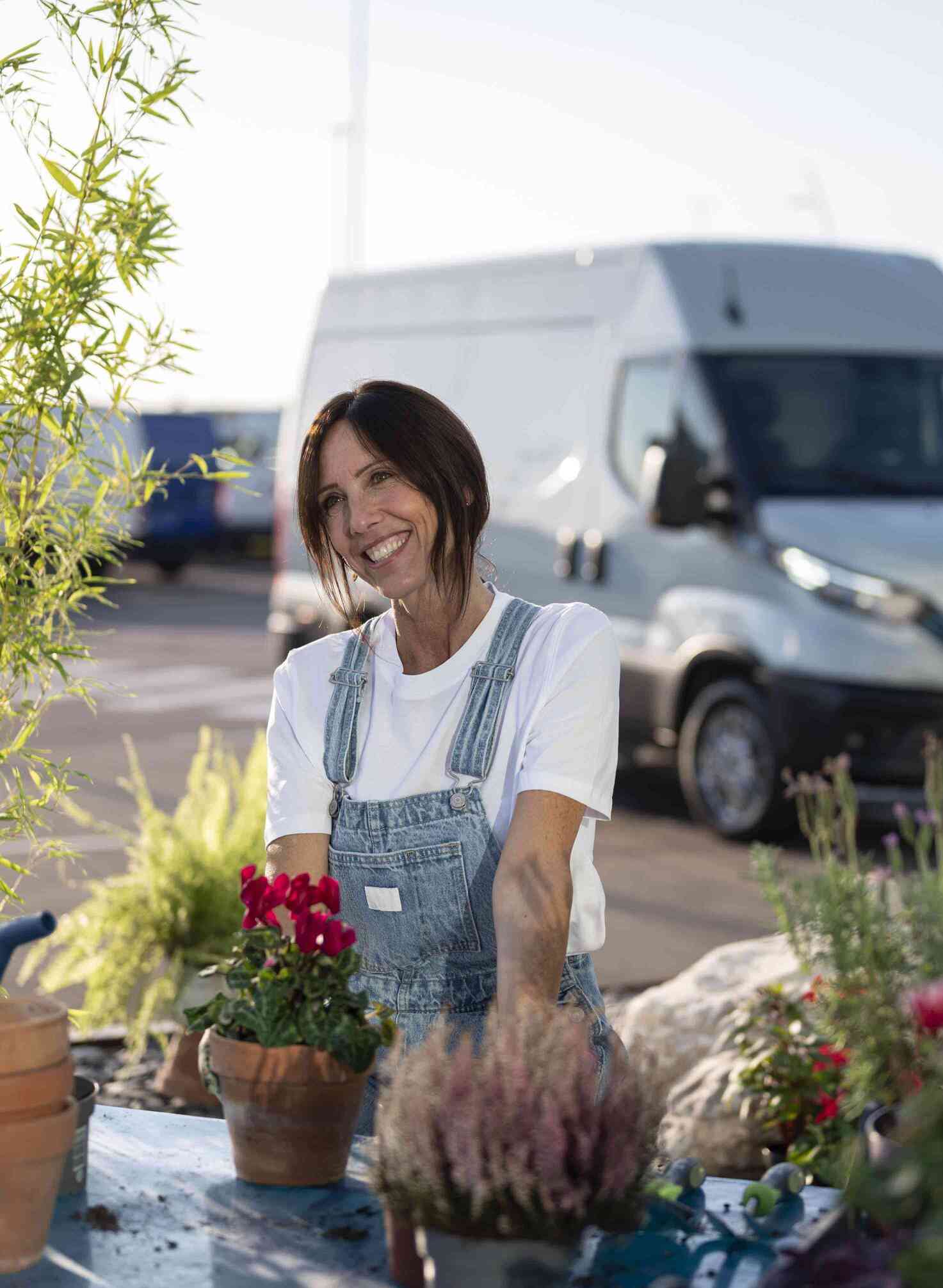 Woman with plants, IVECO eDaily in background.